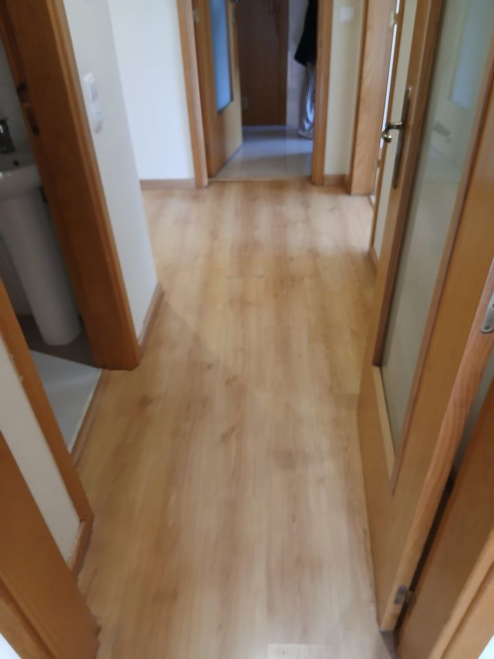 Corredor com porta de vidro e caixilharia nova